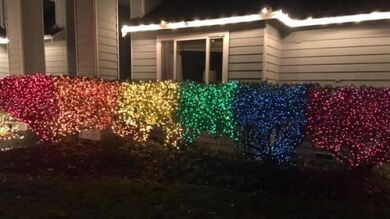 Una mujer enciende las luces de navidad con la bandera de LGTB para desafiar a su vecina homófoba