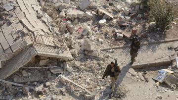 Soldados sirios caminan entre los escombros en el oeste de Alepo 