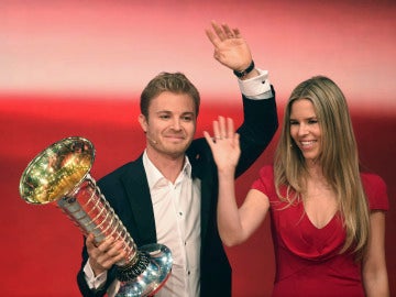 Nico Rosberg, junto a su esposa, sosteniendo el trofeo de campeón