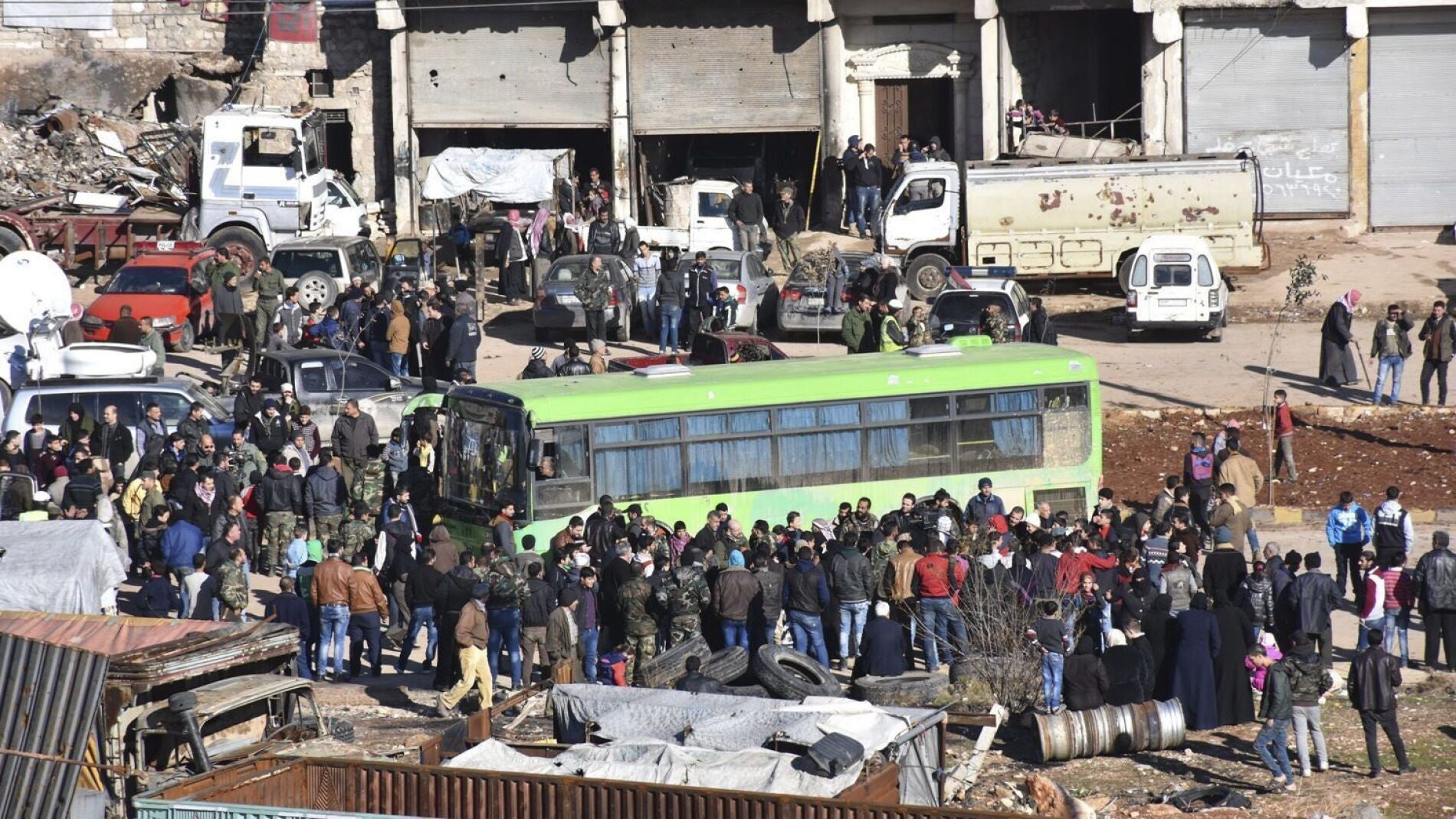 Civiles, combatientes y sus familiares accediendo a uno de los autobuses durante los trabajos de evacuaci&oacute;n de los barrios rebeldes de Alepo
