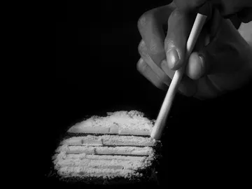 Una persona esnifando cocaína Una persona esnifando cocaína