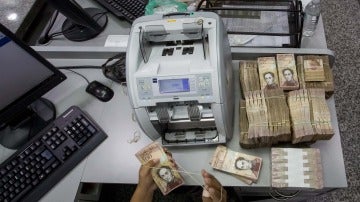 Trabajadoras de un banco cuentan billetes de 100 Bolívares en Caracas (Venezuela)