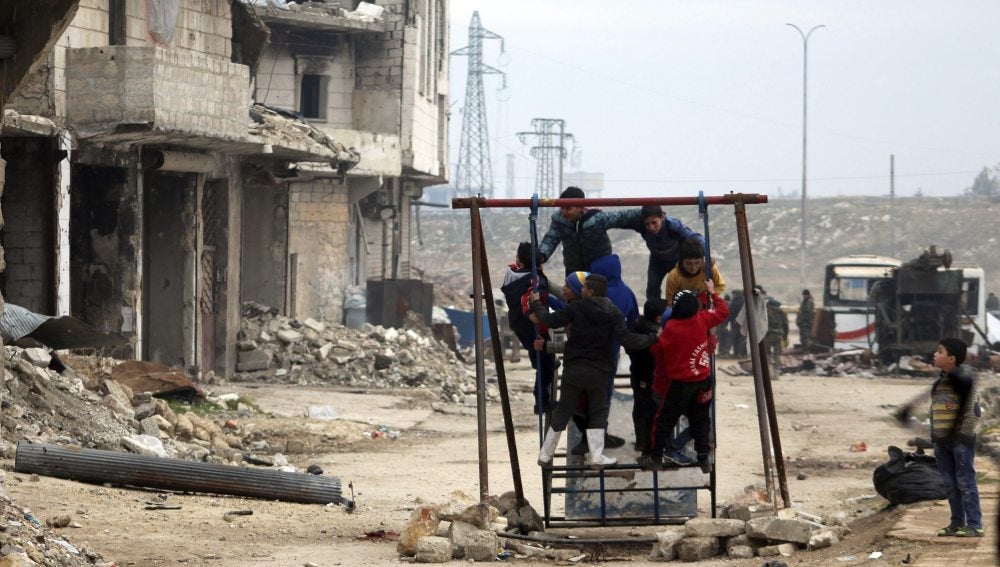 Niños sirios juegan entre las ruinas de una ciudad arrasada por la guerra