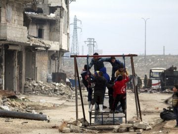 Niños sirios juegan entre las ruinas de una ciudad arrasada por la guerra