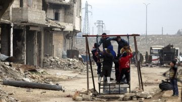 Niños sirios juegan entre las ruinas de una ciudad arrasada por la guerra