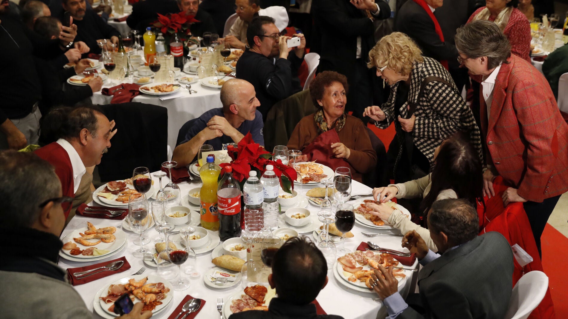 La alcaldesa de Madrid, Manuela Carmena (2&ordf;d), y la vicealcaldesa Marta Higueras (d), felicitan la Navidad a las casi 200 personas sin hogar que acuden a la cena de Nochebuena organizada por Mensajeros de la Paz