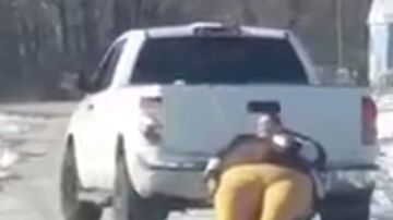 La mujer mientras es arrastrada por la camioneta