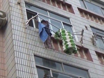 Frame 3.363555 de: Los bomberos salvan a una niña que colgaba de un tendedero en un tercer piso, en China Frame 3.363555 de: Los bomberos salvan a una niña que colgaba de un tendedero en un tercer piso, en China