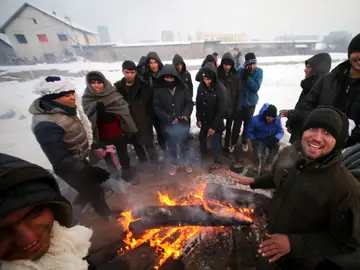 Refugiados intentando entrar en calor en el frío invierno serbio Refugiados intentando entrar en calor en el frío invierno serbio