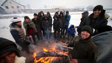 Refugiados intentando entrar en calor en el frío invierno serbio
