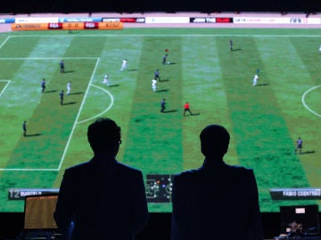 Dos hombres observan un partido del FIFA durante una competición de eSports