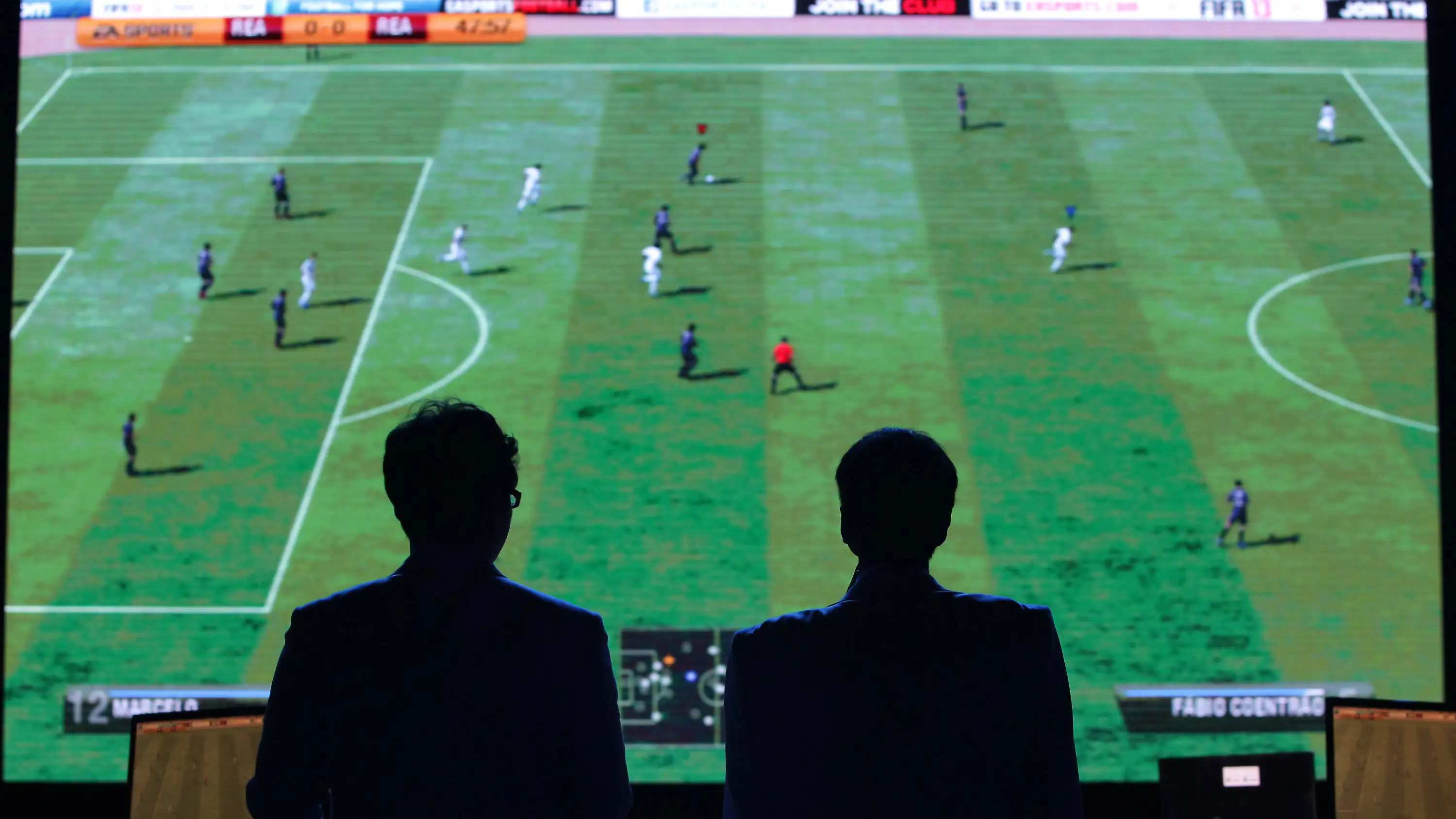 Dos hombres observan un partido del FIFA durante una competición de eSports Dos hombres observan un partido del FIFA durante una competición de eSports