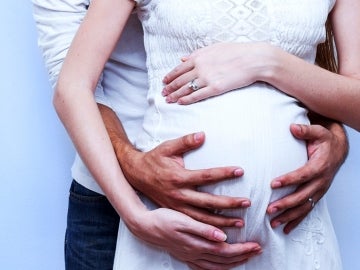 Una pareja abraza la tripa embarazada de la mujer