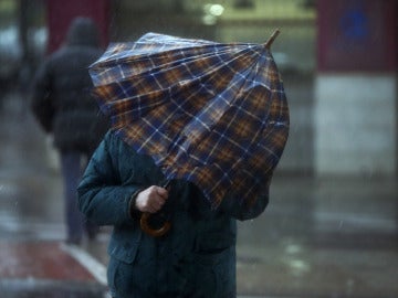 Una persona intenta taparse con un paraguas