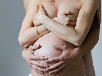 Una mujer embarazada junto a su pareja