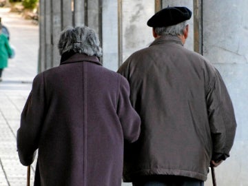 Una pareja de ancianos pasea por la calle