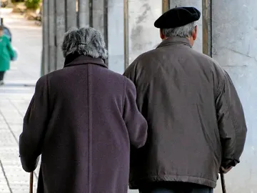Una pareja de ancianos pasea por la calle Una pareja de ancianos pasea por la calle