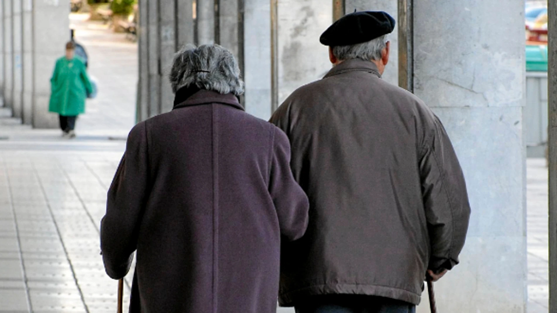 Una pareja de ancianos pasea por la calle Una pareja de ancianos pasea por la calle