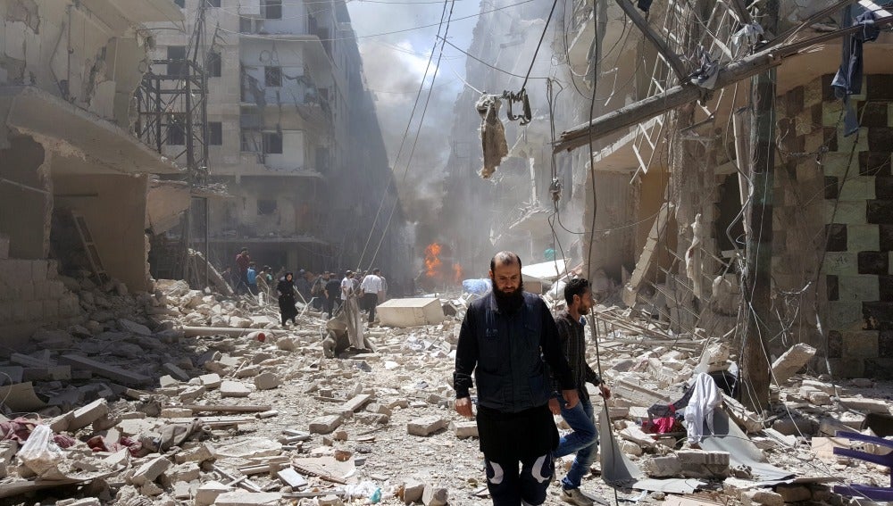 Un hombre camina sobre los escombros de un bombardeo