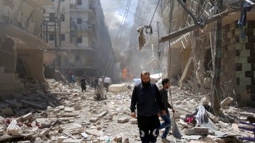 Un hombre camina sobre los escombros de un bombardeo
