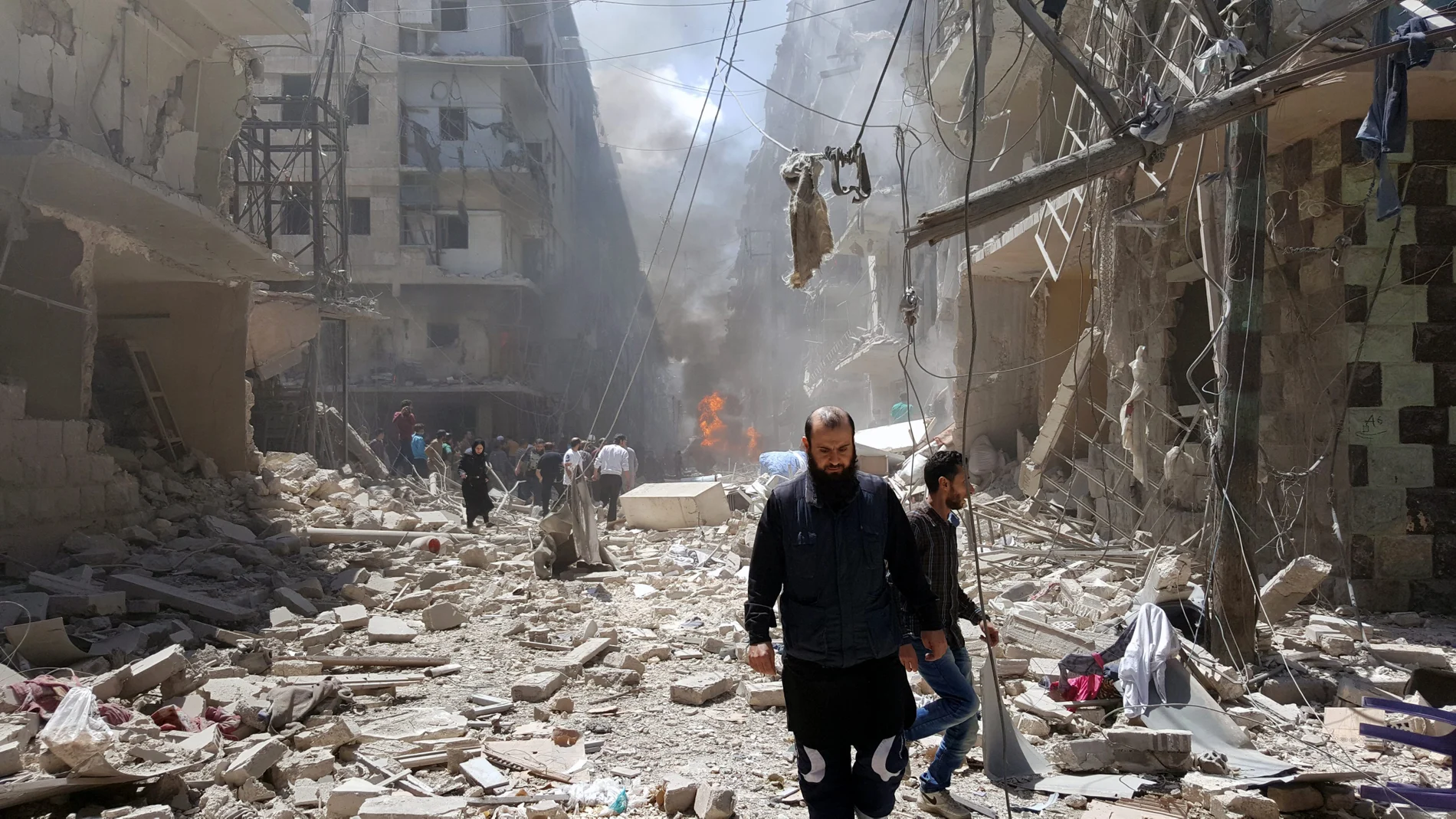 Un hombre camina sobre los escombros de un bombardeo Un hombre camina sobre los escombros de un bombardeo