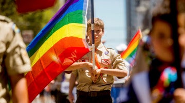 Un Boy Scout portando una bandera gay