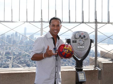 Ronaldinho posa con un balón del Barcelona en el Empire State