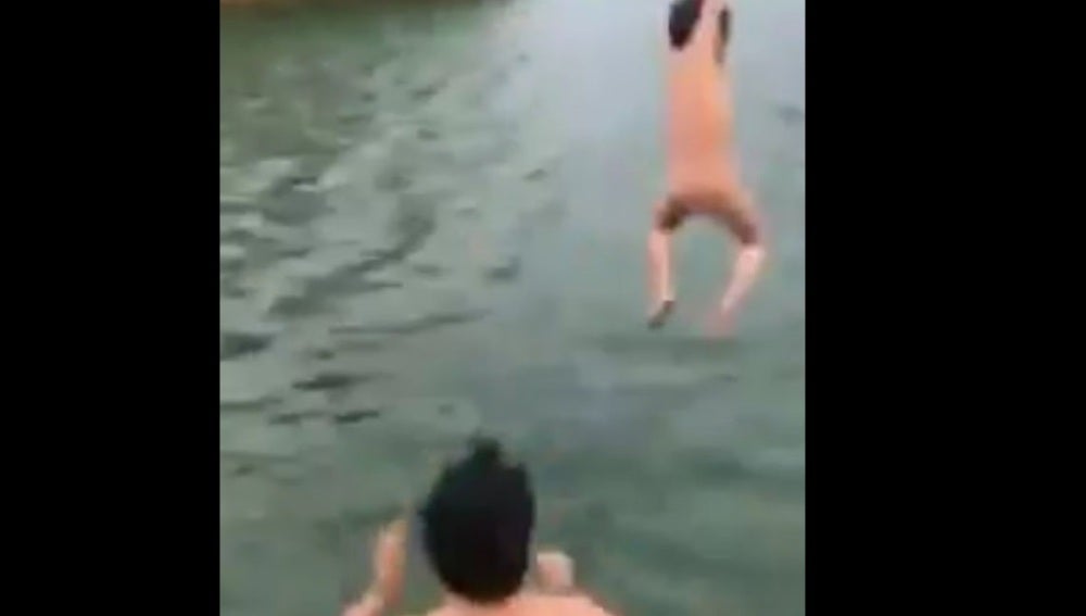 Momento en el que el padre lanza al agua a su hijo