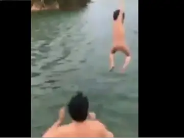 Momento en el que el padre lanza al agua a su hijo Momento en el que el padre lanza al agua a su hijo