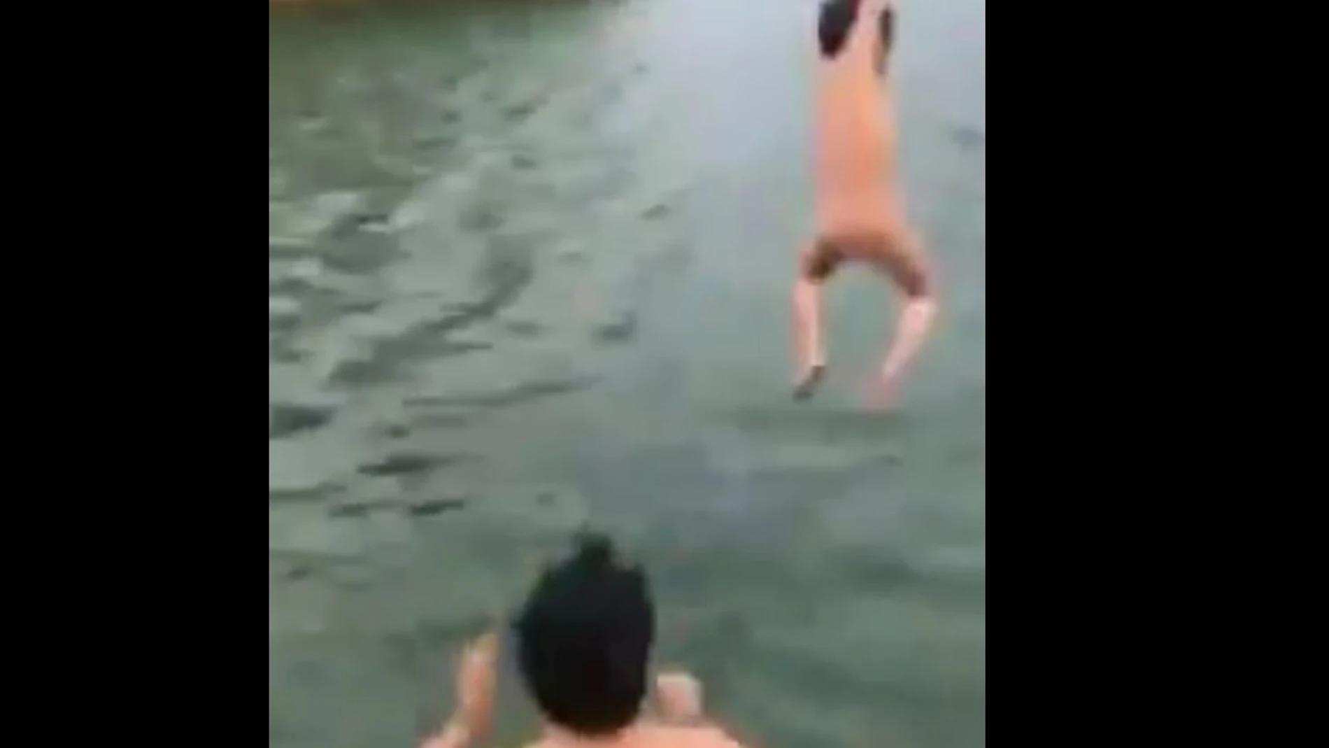 Momento en el que el padre lanza al agua a su hijo Momento en el que el padre lanza al agua a su hijo
