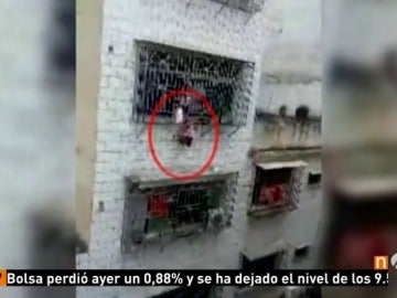 Frame 8.235555 de: Arriesgan su vida para rescatar a una niña que se había quedado atrapada por la cabeza entre las rejas de una ventana