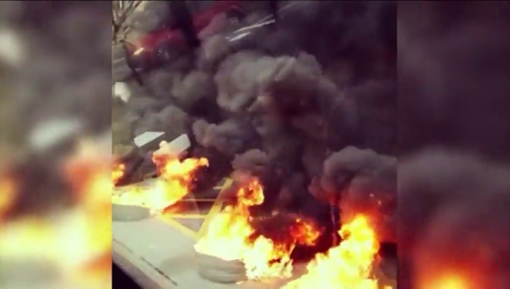 Frame 26.737777 de: Cortes de tráfico en varias calles de Barcelona por la quema de contenedores y neumáticos