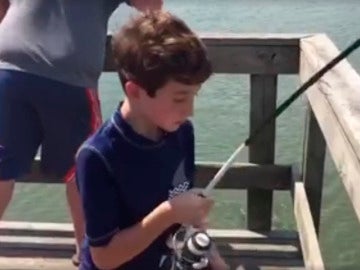 El niño tras capturar al pez