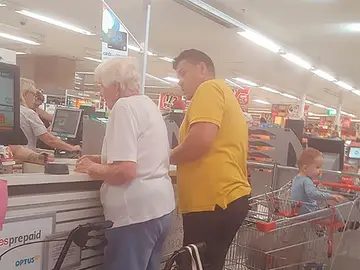 Momento en el que el hombre paga la compra a la anciana Momento en el que el hombre paga la compra a la anciana