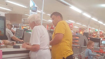 Momento en el que el hombre paga la compra a la anciana