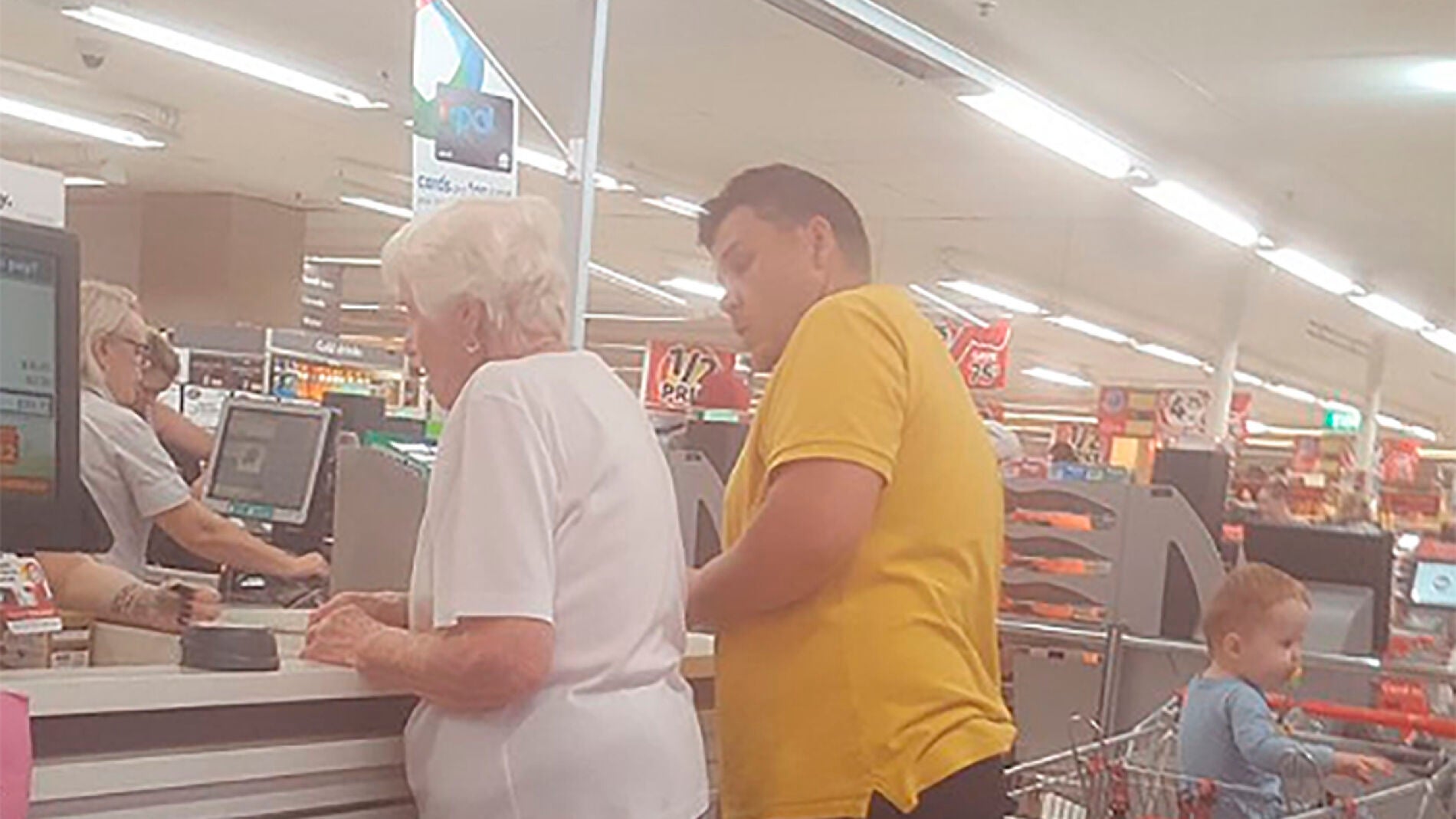 Momento en el que el hombre paga la compra a la anciana