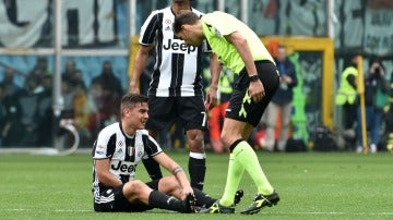 Dybala sentado en el terreno de juego