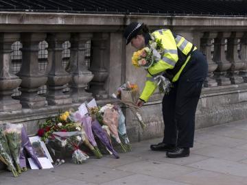 Una agente de la Policía deposita flores cerca del Parlamento 
