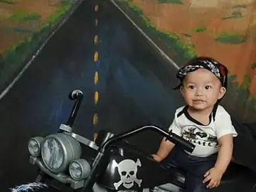 Un bebé con tacones subido a una moto Un bebé con tacones subido a una moto