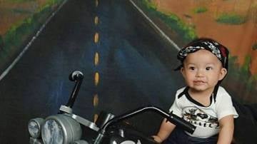 Un bebé con tacones subido a una moto