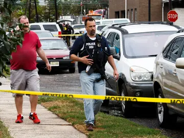 Oficiales de policía trabajan en la escena de un tiroteo Oficiales de policía trabajan en la escena de un tiroteo