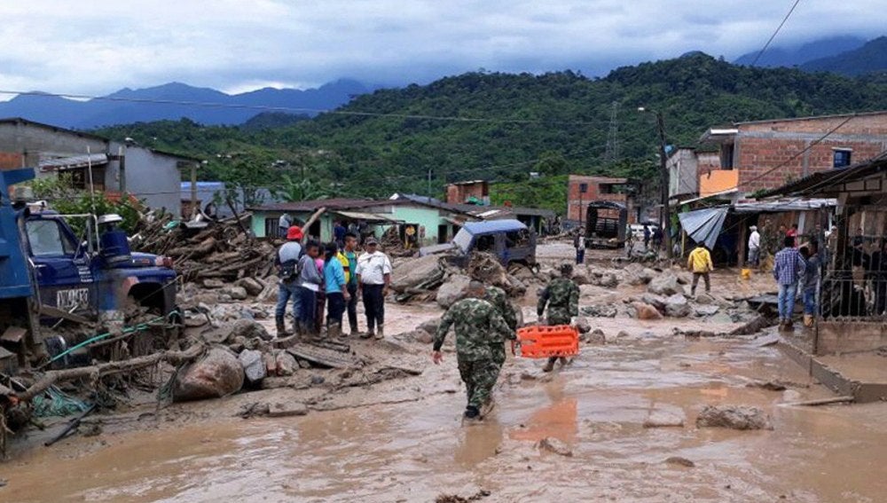 Fotografía cedida por el Ejército de Colombia de sus integrantes ayudando a pobladores por los estragos ocasionados por una avalancha
