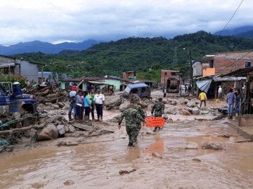 Fotografía cedida por el Ejército de Colombia de sus integrantes ayudando a pobladores por los estragos ocasionados por una avalancha