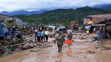 Fotografía cedida por el Ejército de Colombia de sus integrantes ayudando a pobladores por los estragos ocasionados por una avalancha