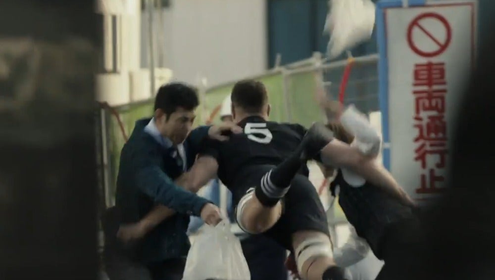 Un miembro de los All Blacks, placando a dos japoneses