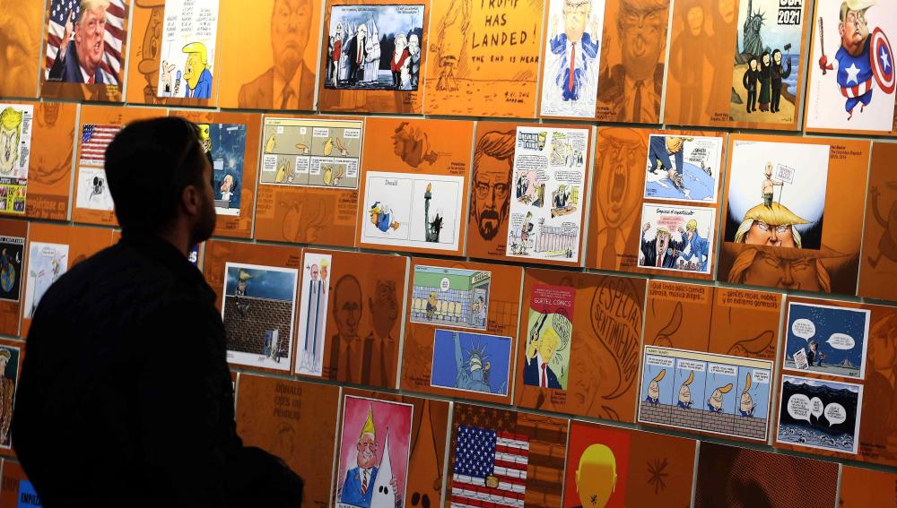 Un visitante observa varios "retratos" de Donald Trump en el Salón del Cómic de Barcelona