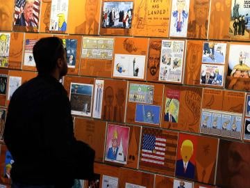 Un visitante observa varios "retratos" de Donald Trump en el Salón del Cómic de Barcelona