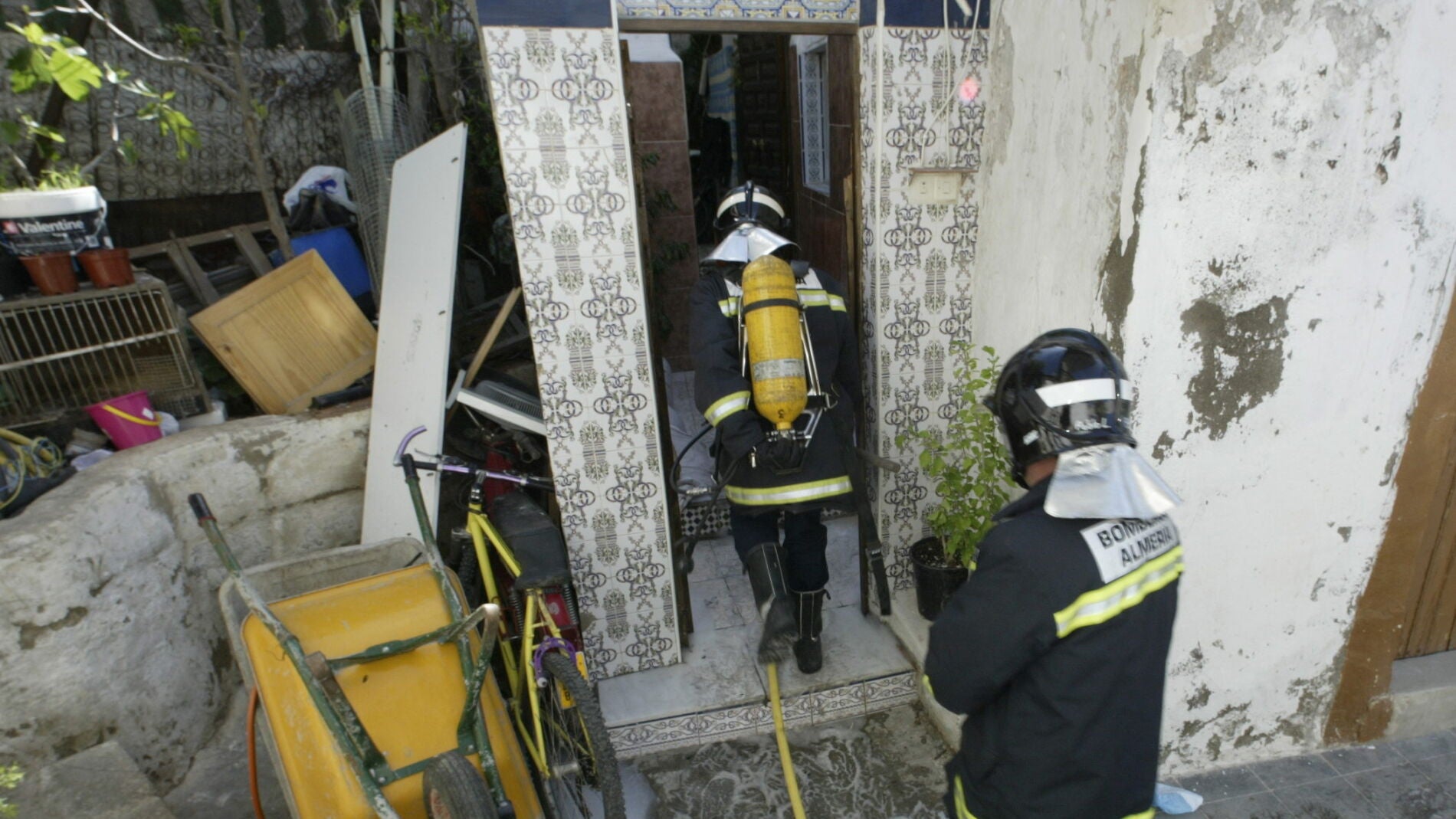 Dos bomberos trabajan en la extinci&oacute;n de un incendio en una casa cueva