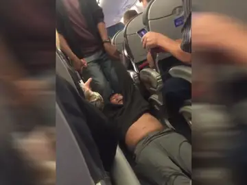 Pasajero arrastrado fuera de un avión por overbooking Pasajero arrastrado fuera de un avión por overbooking