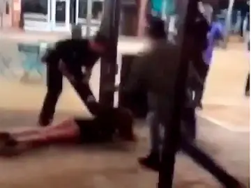 Un policía tumba a una joven en el suelo en plena calle Un policía tumba a una joven en el suelo en plena calle